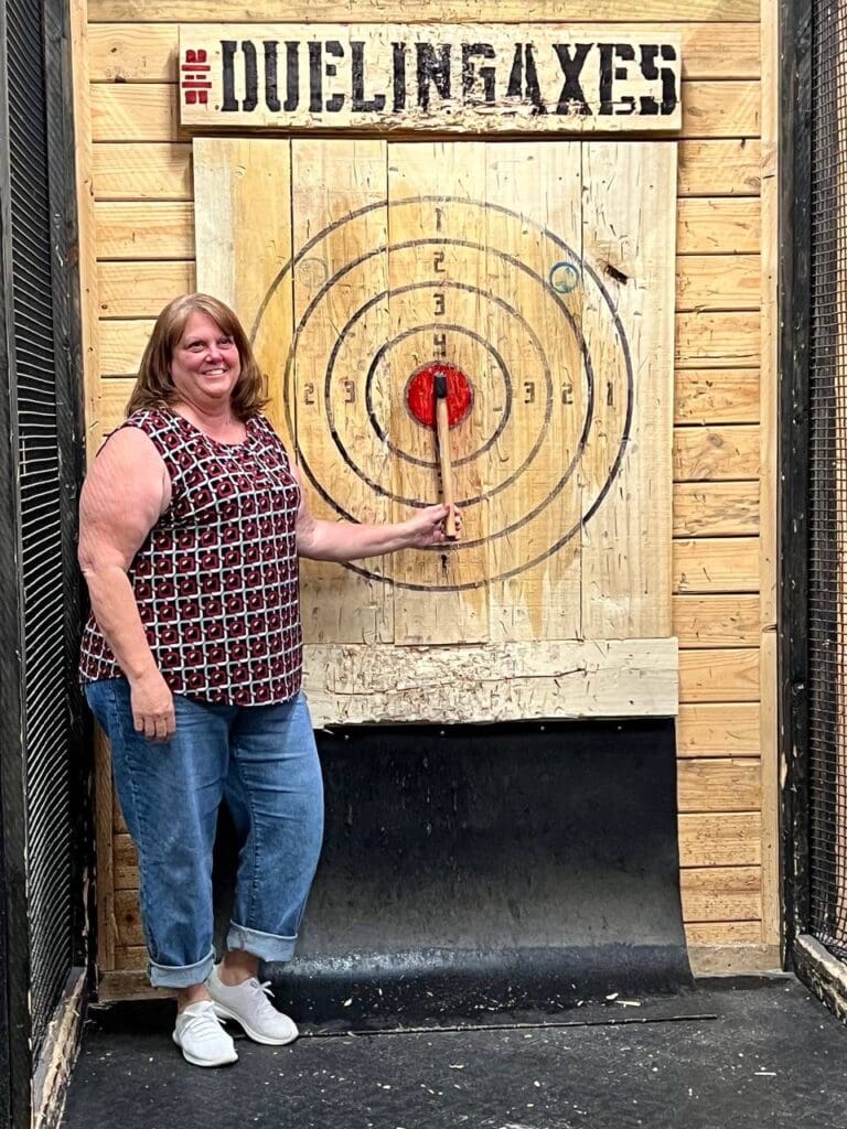 Woman posing with her perfect bullseye while axe throwing in Columbus, OH at Dueling Axes