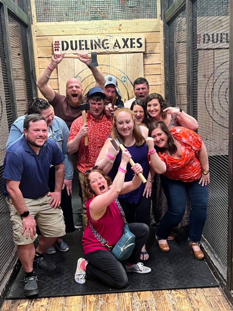 People posing for a picture during their group axe throwing reservation at Dueling Axes