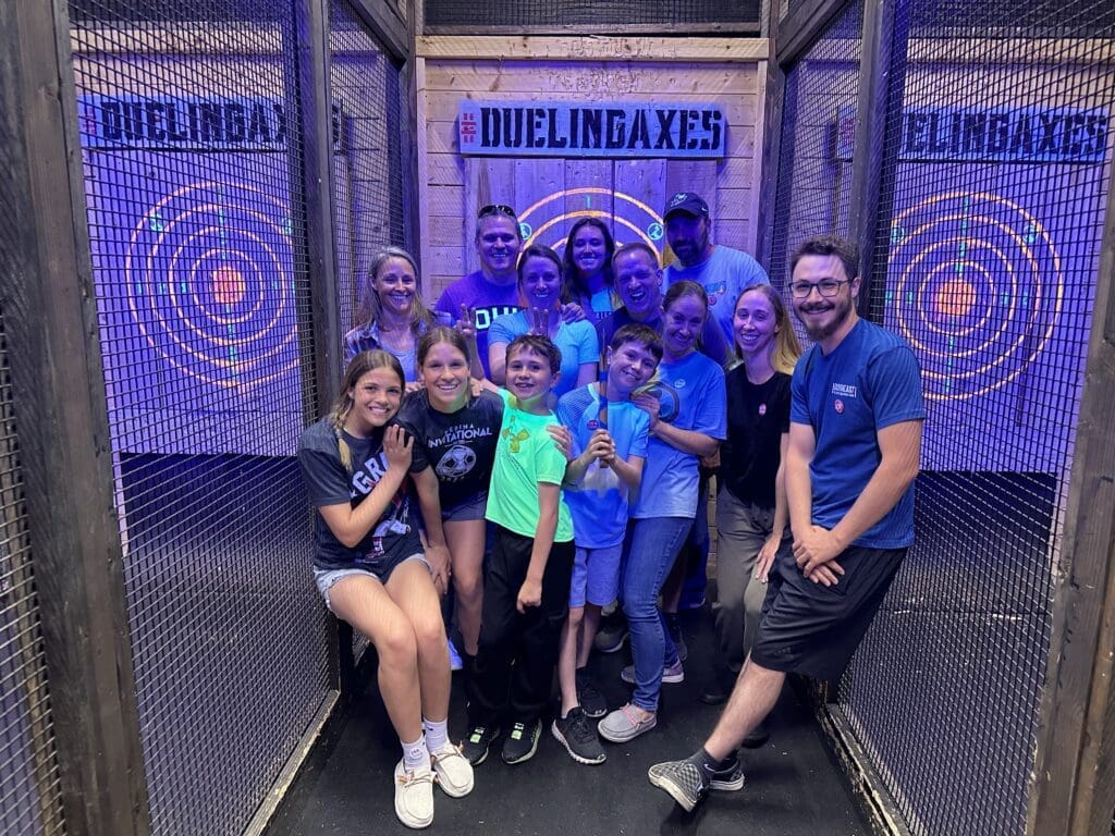 Family in Columbus posing for a group picture at an axe throwing lounge. 