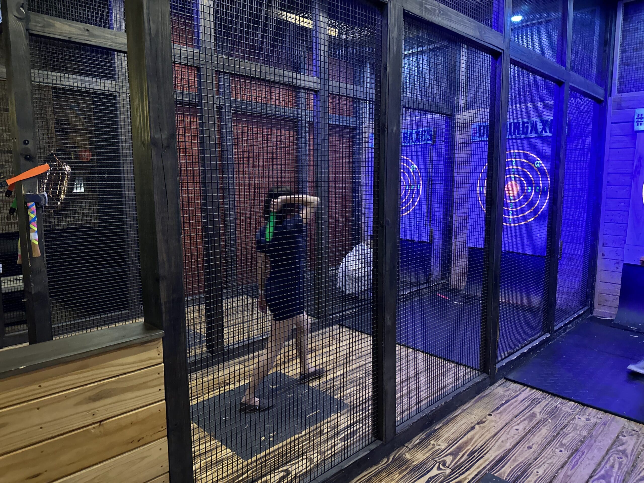 Woman throwing UV reactive throwing knives at Dueling Axes