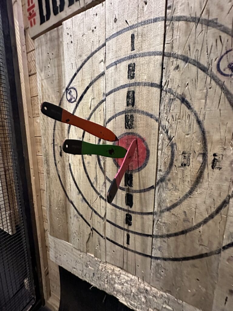 Throwing knives hitting the bullseye at a an Ohio axe throwing bar.